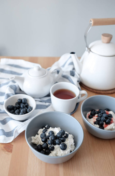 Healthy breakfast with cottage cheese and blueberries, freshly brewed tea - Photo, image