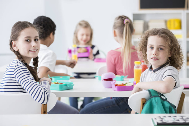 Uśmiechnięta dziewczyna i chłopak, jedzenie zdrowe śniadanie podczas przerwy w szkole - Zdjęcie, obraz