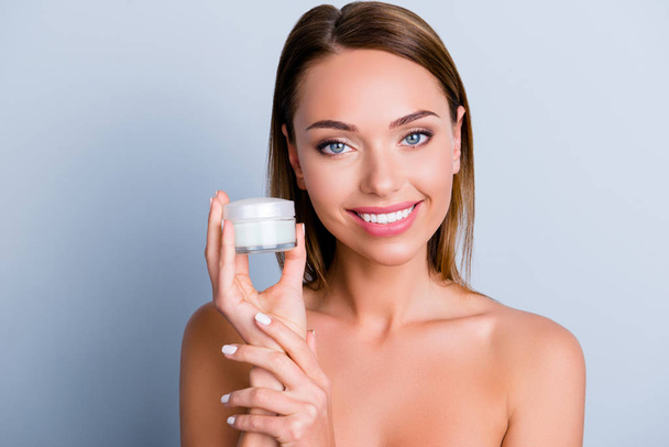 Oily dry ideal perfect pure flawless skin brunette foundation soft smooth tone no makeup sensual apply clean clear concept. Portrait of lovely girl shows white jar with cream isolated gray background - Zdjęcie, obraz