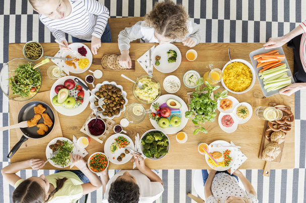 Top view on children eating healthy food during friend's birthday party - Фото, зображення