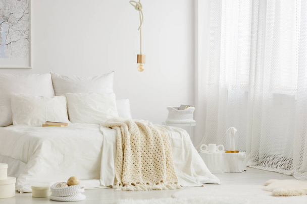 White simple bedroom interior with double bed, knit blanket and windows with curtains - Valokuva, kuva