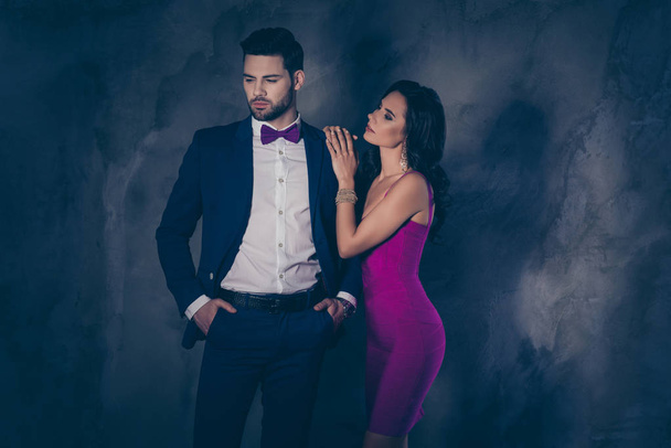 Side view portrait of charming slim pretty woman putting arms on shoulder of dreamy bearded man in blue tux holding two hands in pockets of pants  attractive spouses isolated on grey background - Φωτογραφία, εικόνα