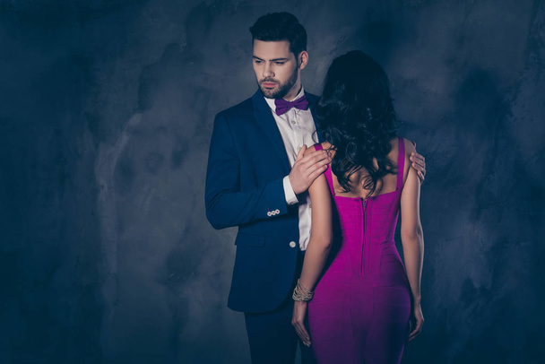 Rear view of pretty brunette woman with curly hair booty bum harsh man in tux with bow holding hands on shoulders of lover attractive couple isolated on grey background with copy space empty place - Φωτογραφία, εικόνα
