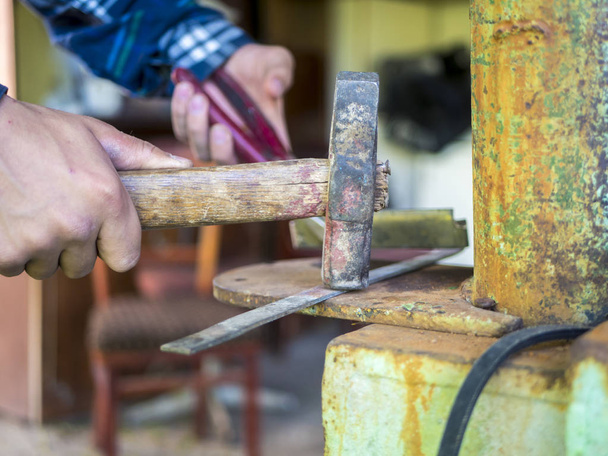 persona que trabaja en taller usando martillo
  - Foto, imagen