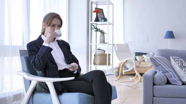 ソファに座ってコーヒーを飲む女性 - 写真・画像