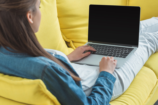 rajattu kuva nuori nainen käyttää kannettavaa tietokonetta tyhjä näyttö sohvalla kotona
 - Valokuva, kuva