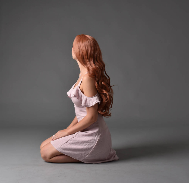 Ολόσωμο πορτρέτο του κοριτσιού που φοράει φόρεμα πανκ καλοκαίρι, καθιστή στάση σε φόντο γκρι στούντιο. - Φωτογραφία, εικόνα