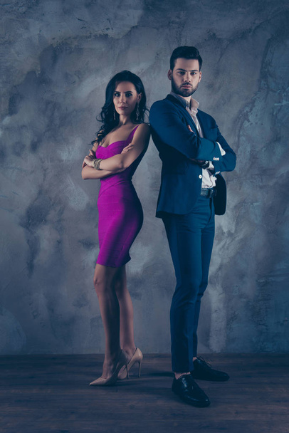Opposites attract! Full size fullbody vertical portrait of attractive, confident couple with crossed arms looking at camera pretty slim lady purple tight dress gentlemen in tux standing over grey wall - Photo, Image