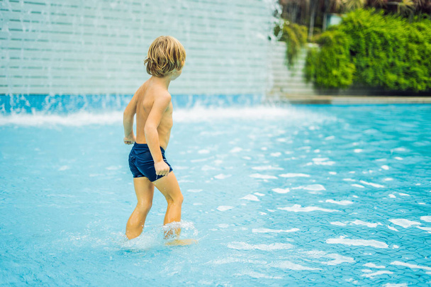 Small boy having fun and running in swimming pool - Foto, Imagem