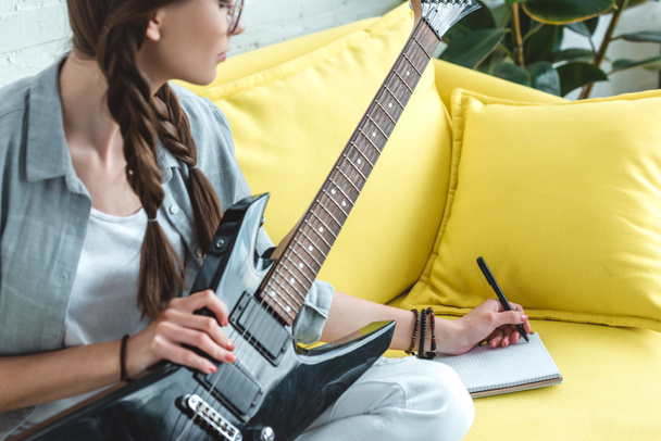atractiva chica adolescente tocando la guitarra eléctrica y escribiendo canción
   - Foto, imagen