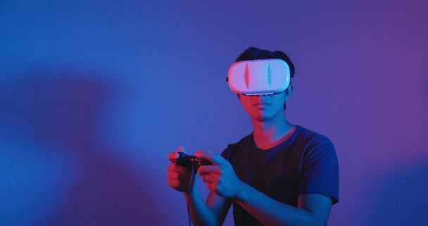 Чоловік грає в гру з пристроєм VR
  - Фото, зображення