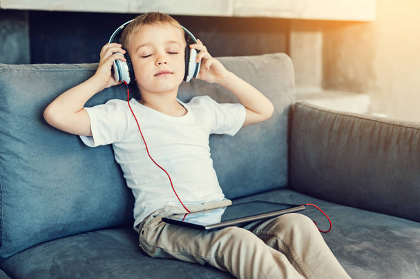 Relaxation. Pleasant little relaxed child sitting with his eyes closed while listening to the calm music - Foto, Imagem