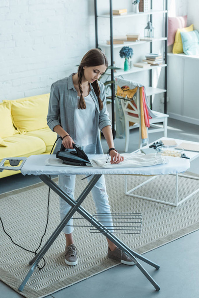 attractive youth girl ironing in living room  - Foto, Bild
