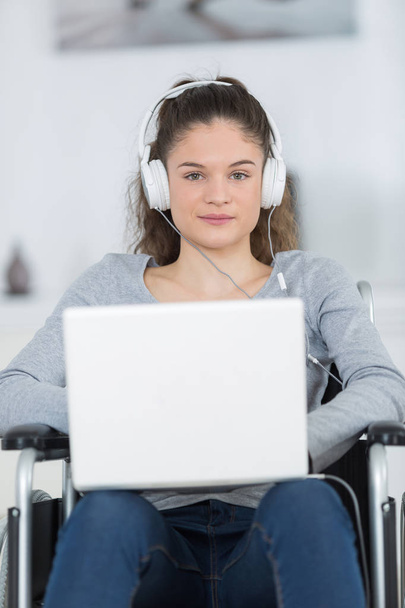 Vammainen nainen kuuntelemassa musiikkia kotona
 - Valokuva, kuva