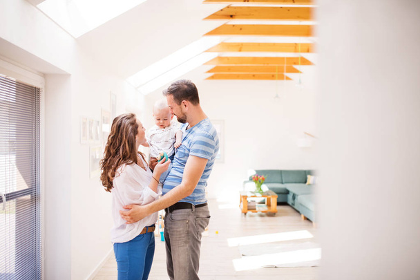 Young family with a baby boy at home, standing. - Foto, Imagen