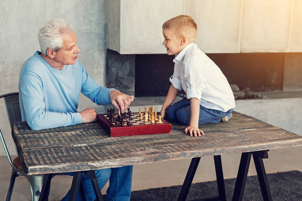 freundlich lächelnder Opa mit Blick auf seinen smarten Enkel - Foto, Bild