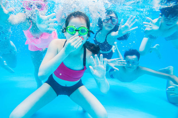 little kids swimming  in pool  underwater. - Фото, изображение