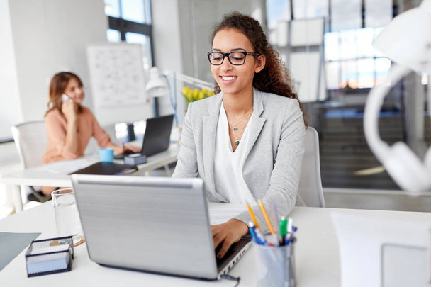 happy businesswoman with laptop working at office - Zdjęcie, obraz