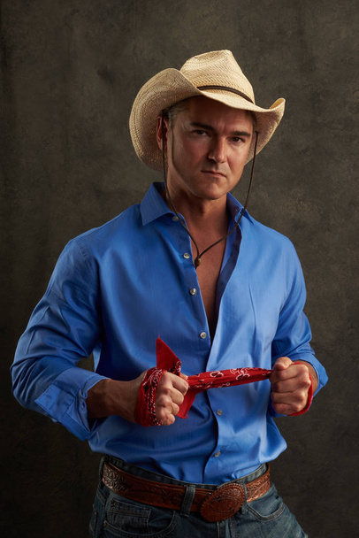 De sexy cowboy draagt een blauw shirt. - Foto, afbeelding
