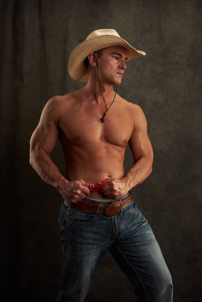 De sexy cowboy pronkt met zijn spieren - Foto, afbeelding