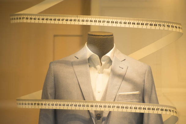 テープを測定する場合の正式なシャツにテーラード スーツ店マネキンとネクタイをあつらえ仕立て屋の店の窓. - 写真・画像