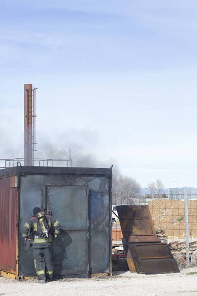 Tűzoltóság tűzoltó képzés által használt felszereléseket, tűzoltó szimulálni tüzek fúrók gyakorolni, amivel ki a lángok. - Fotó, kép