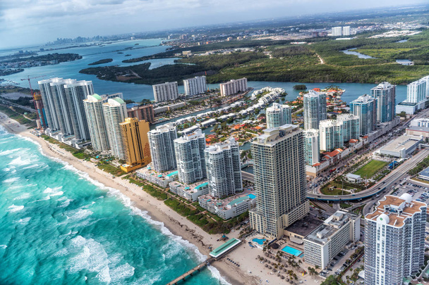 Vista aérea del horizonte de North Miami Beach con sol y nubes
. - Foto, Imagen