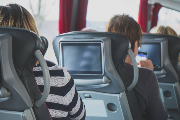 観光バスの乗客と内蔵の液晶タブレット. - 写真・画像