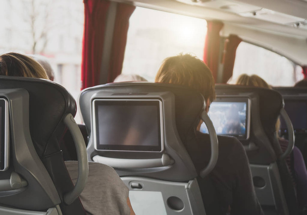 Toeristische bus met passagiers en ingebouwde LCD-tabletten. - Foto, afbeelding