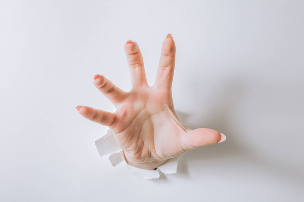 дівчина рука розбиває білий папір і показує жест
. - Фото, зображення
