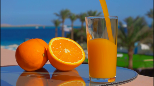 χυμό πορτοκαλιού χύνεται ένα ποτήρι - Πλάνα, βίντεο