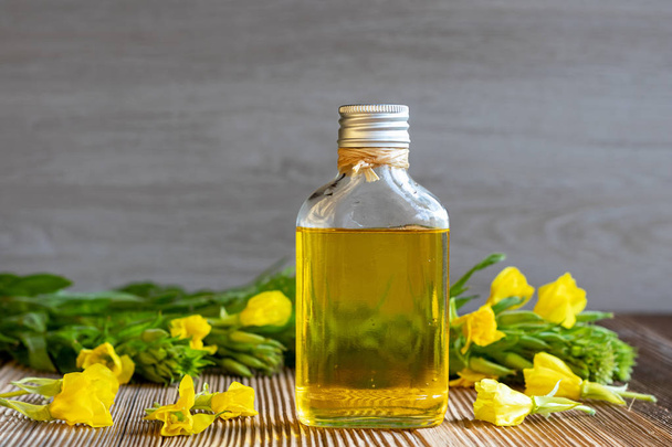 Вечернее масло и свежее цветущее растение
 - Фото, изображение
