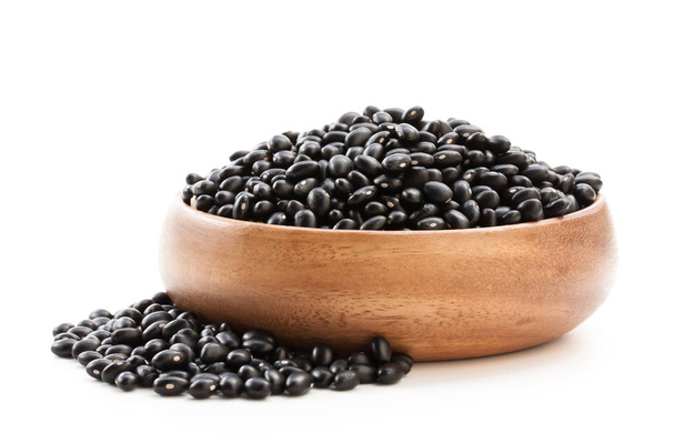 Raw  black beans in wooden bowl isolated on white  - Photo, image