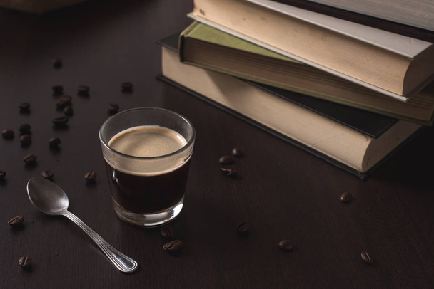 heißer Espresso-Kaffee mit Büchern auf einem braunen Holztisch - Foto, Bild