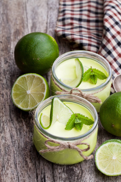 Natural  lime yogurt in a small glass jar on wooden table  - Foto, Imagem