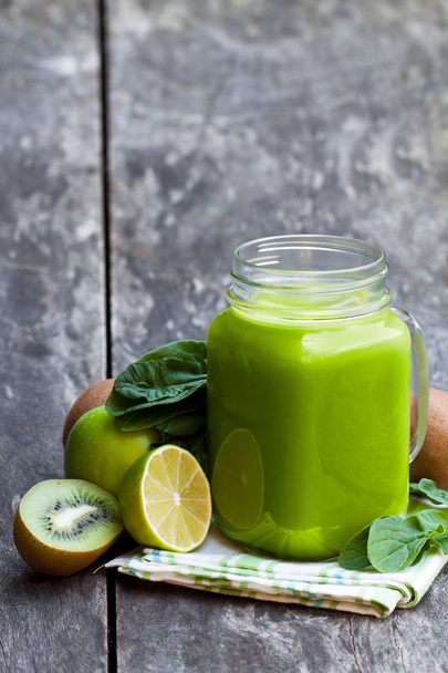 Fresh  smoothie with green fruits in a glass jar mug on wooden table  - Φωτογραφία, εικόνα