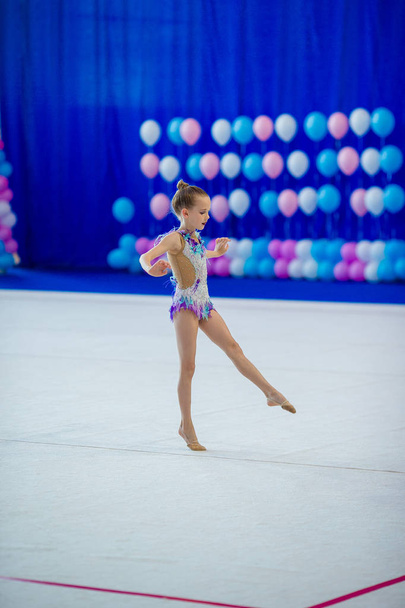 Halıda performansı olan küçük, güzel, aktif bir jimnastikçi kız. - Fotoğraf, Görsel