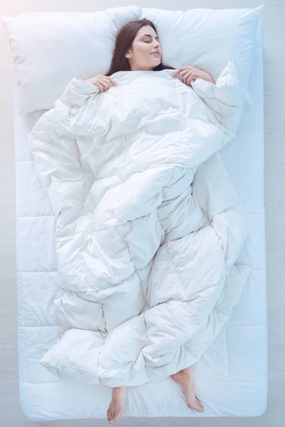 junge Dame schläft im Bett mit Bettdecke über - Foto, Bild