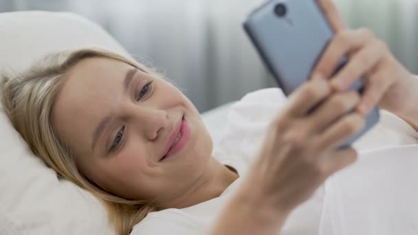 Teenage girl smiling while reading message from boyfriend in morning, first love - Video