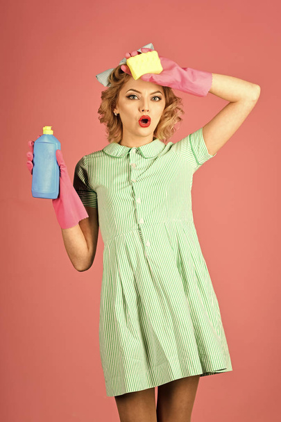 detergents. Cleaning, retro style, purity. Cleanup, cleaning services, wife, gender. Pinup woman hold soup bottle, sponge. Retro woman cleaner on pink background. Housekeeper in uniform with clean - Photo, image