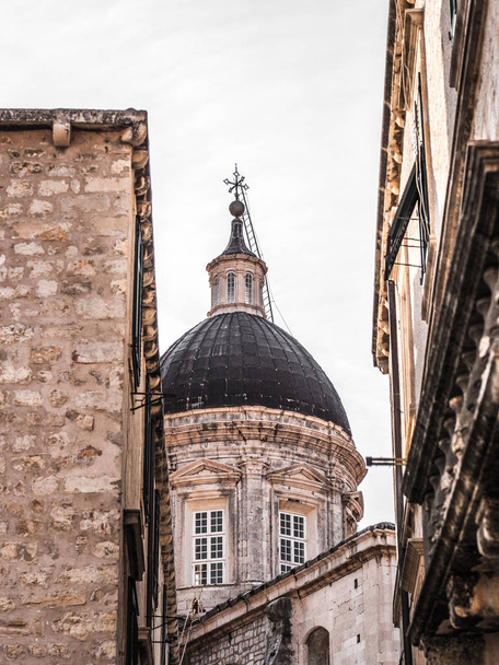 Architecture detail photograph of the domed top of the Assumption Cathedral Christian church in the old town in Dubrovnik Croatia with a gray sky above. - Foto, Imagem