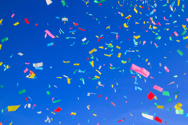 multicolored confetti on clear blue sky background. concept of holiday backdrop - Foto, Imagem