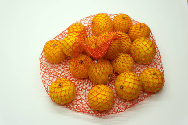 A lot of oranges packaged in netting to be sell in a fruits stall - Фото, зображення