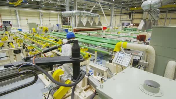 bovenste deelvenster werknemers in witte beschermende uitrusting controle speciale buizen productie in grote lichte werkplaats - Video