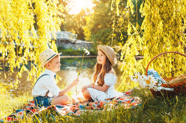 Summer. Beautiful kids on a date. The love, the joy of children.Give flowers - Photo, Image