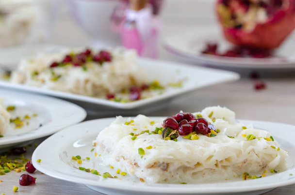 Tradizionale Ramadan Dessert Gullac sul tavolo. È fatto con gullac, latte, acqua di rose, noce, vaniglia. È decorato con melograno e pistacchio
. - Foto, immagini