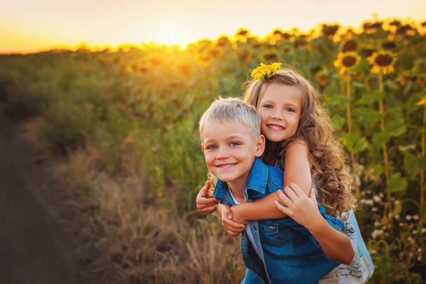 V létě. Krásný děti na poli slunečnic. Dětská láska. Zábava pro děti - Fotografie, Obrázek