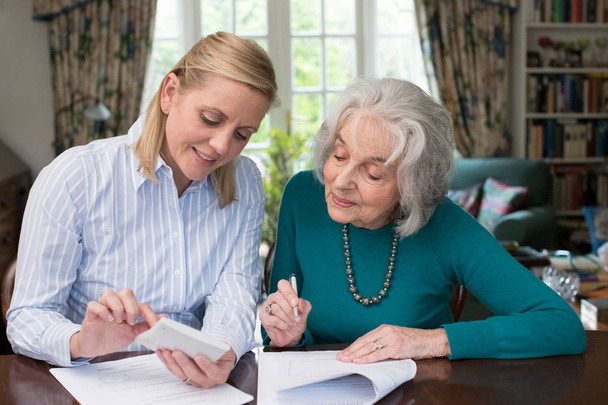 Woman Helping Senior Neighbor With Paperwork - Fotografie, Obrázek