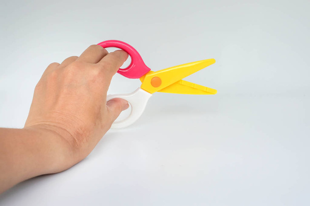 isolated woman holds zigzag scissors for cutting with left hand - Φωτογραφία, εικόνα
