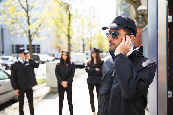 Close-up Of A Young Male Security Guard Listening With Earpiece - Φωτογραφία, εικόνα
